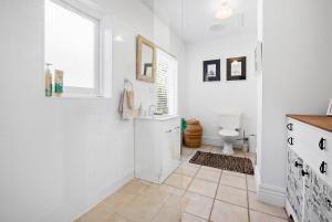 een witte badkamer met een wastafel en een toilet bij Coral Rose Cottage in Capel Sound +20 foto's