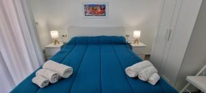 a bedroom with a blue bed with towels on it at Sul Mare Apartment - Seafront with Sea View in Salerno