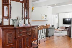een woonkamer met een houten dressoir en een woonkamer bij Coral Rose Cottage in Capel Sound