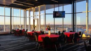 una sala de conferencias con mesas, sillas y una pantalla en Grand Times Hotel Drummondville, en Drummondville