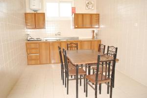 a kitchen with a wooden table and chairs in it at البرنس الذهبي للشقق المخدومة حي السلام- اقتصادي in Buraydah