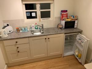 a kitchen with a sink and a microwave at Field Cottage Bed and Breakfast in East Harling