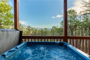 a hot tub on a deck with a view of the mountains at Smoky Overlook in Sevierville