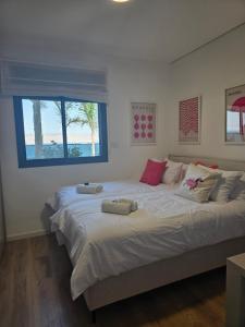 a large bed in a bedroom with a window at Levication Tiberias Luxury Private Pool Apartments in Tiberias +130 photos