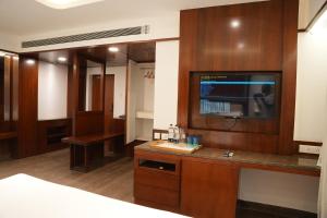 a hotel room with a bed and a tv on a wall at Lords Hrim Akshara Resort in Rāmāyampet