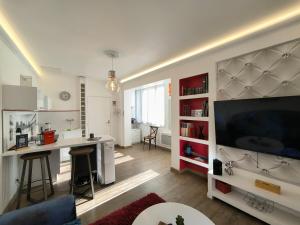 a living room with a large television and a desk at Appartement Centre Ville Cosy in Pau