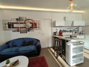a living room with a blue couch and a desk at Appartement Centre Ville Cosy in Pau +15 photos