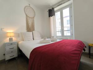 a bedroom with a bed with a red blanket and a window at Appartement Centre Ville Cosy in Pau