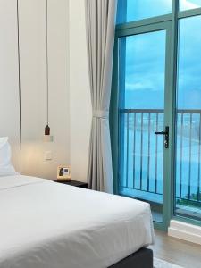 哥打京那巴鲁Deluxe 1BR Seaview and Mountain View with balcony的一间卧室,里面有一张床和一扇大窗户。