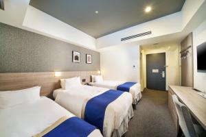 a hotel room with two beds and a television at Best Western Plus Hotel Fino Osaka Kitahama in Osaka +101 photos