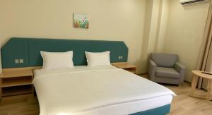 a bedroom with a bed with a green headboard and a chair at Holiday Village Interpark in Kranevo +24 photos