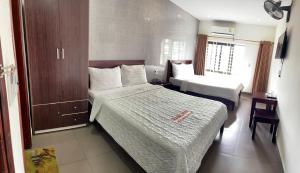 a small hotel room with two beds and a desk at Khách sạn Global in Yên Dung (1)