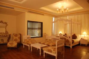 a bedroom with a bed and a couch and a table at The Nagpur Ashok in Nagpur