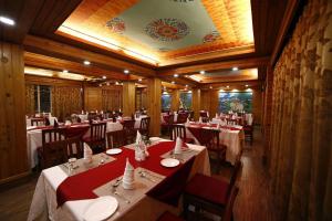 a dining room with tables and chairs with red table cloth at Hotel Sikkim Tourist Centre in Pelling
