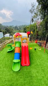 - une aire de jeux avec toboggan sur l'herbe dans l'établissement locera resort, à Meppādi