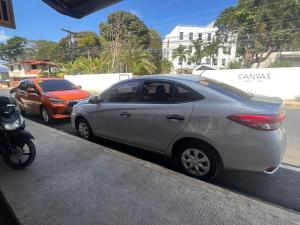 zwei Autos, die am Straßenrand geparkt sind in der Unterkunft Car Rental Palawan CoolExtreme Rent A Car Palawan Car Rentals in Puerto Princesa