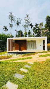 une petite maison avec un balcon dans l'établissement locera resort, à Meppādi 27 autres photos
