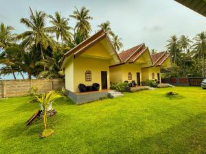 a house with a lawn in front of it at Hai Surf Camp in Karbang