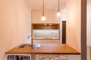 a kitchen with a sink and a microwave at Forgotten Garden Apartments and Rooms in Portorož