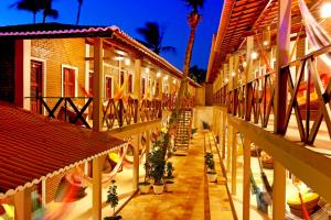 a courtyard of a building with potted plants and lights at Rede Andrade Pousada do Norte in Jericoacoara