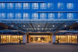 a large blue building with a lot of windows at Hotel Neo Plus Airport Jakarta in Tangerang