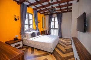 富国Skyline Hotel Phú Quốc的一间卧室设有床铺、电视和黄色的墙壁