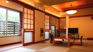 a living room with a table and a window at Ryokan Maruya in Yufuin
