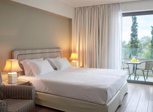 ein Schlafzimmer mit einem großen Bett und einem Balkon in der Unterkunft Amarilia Hotel in Athen