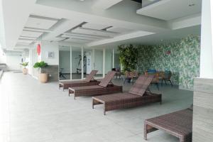 a lobby with a row of chairs and tables at Cozy Studio at Mataram City Apartment By Travelio in Kejayan