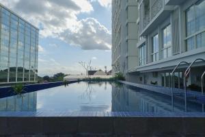 a swimming pool in the middle of a building at Cozy Studio at Mataram City Apartment By Travelio in Kejayan
