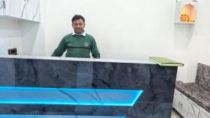 a man standing behind a counter with at Neelkanth pg house in Varanasi