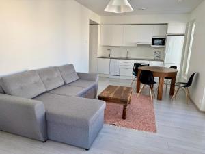a living room with a couch and a table and a kitchen at Cozy apartment - Free WIFI in Espoo