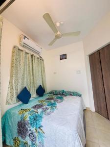 a bedroom with a bed and a ceiling fan at Trupti Villa & Cottages-Nagaon- Three BHK Villa in Alibaug +25 photos