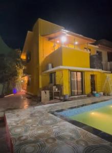 a house with a swimming pool at night at Trupti Villa & Cottages-Nagaon- Three BHK Villa in Alibaug