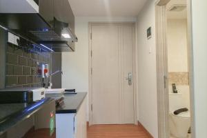 a kitchen with a sink and a toilet at Cozy Studio at Mataram City Apartment By Travelio in Kejayan