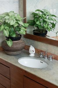 a bathroom sink with two potted plants and a mirror at Pasteur Beautiful Luxury Home in Bandung +63 photos