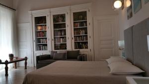 カターニアにあるCentro Storico B&Bのベッドルーム(ベッド1台、ソファ、本棚付)
