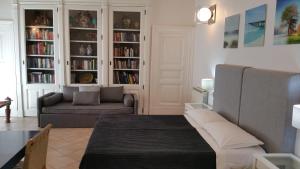 ein Wohnzimmer mit einer Couch und einem Bücherregal in der Unterkunft Centro Storico Home in Catania
