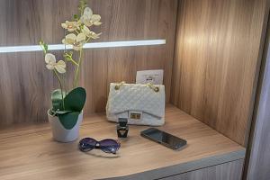 a shelf with a purse and glasses and a cell phone at Hotel Madison in Bellaria-Igea Marina