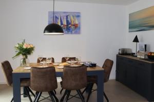 une salle à manger avec une table et des chaises bleues dans l'établissement Ferienhaus Ellomi - Klausdorf, à Klausdorf