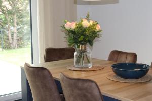 une table avec un vase de fleurs et un bol dessus dans l'établissement Ferienhaus Ellomi - Klausdorf, à Klausdorf