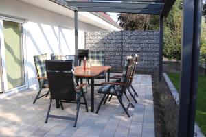 - une table et des chaises sous un parasol sur la terrasse dans l'établissement Ferienhaus Ellomi - Klausdorf, à Klausdorf