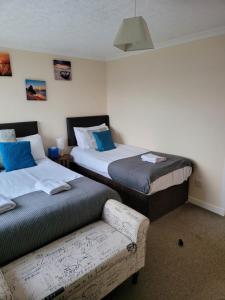 a room with two beds and a bench in it at Corran House in Kingsburgh