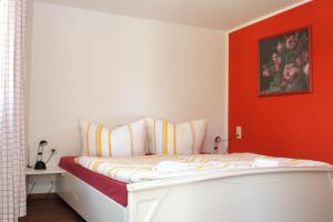 a bed in a room with a red wall at Ferienhaus "Am Papststein" in Papstdorf