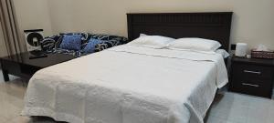 a bedroom with a large white bed and a desk at Villa 6 in Ajman 