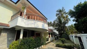 una casa con un balcón encima en Pinky's Villa, en Trivandrum
