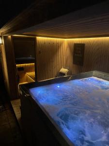 a large hot tub in a bathroom with aperature at TauberChalet I Privates Boutique-Ferienhaus mit Whirlpool, Sauna, Garten, Naturmagie & ZellBoost in Rothenburg ob der Tauber