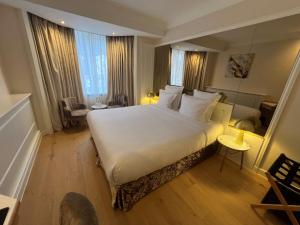 a bedroom with a large white bed and some windows at Maison LUTETIA R in Strasbourg