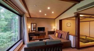 a living room with a couch and a large window at Hotel Harvest Tateshina in Tateshina
