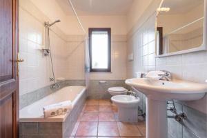 a bathroom with a sink and a tub and a toilet at Casa Pompia 6 in Siniscola +19 photos